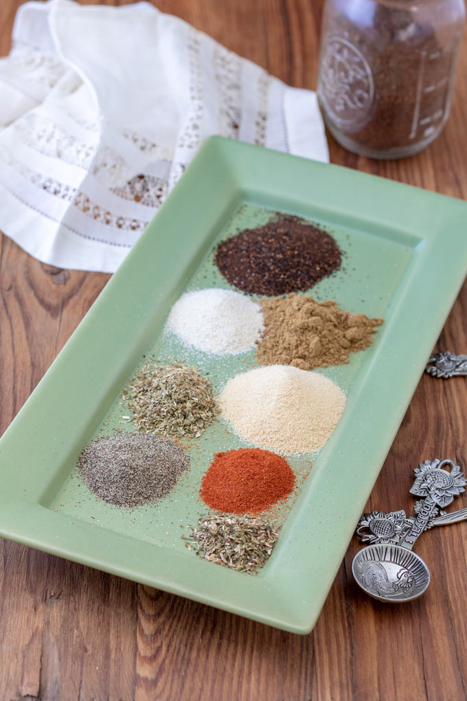 ingredients for taco seasoning with plate with wooden background