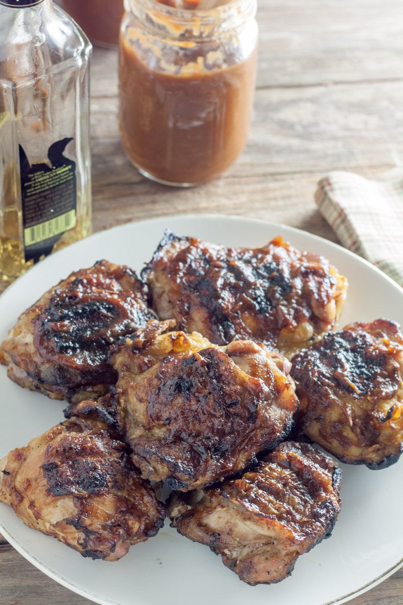 Overhead photo of Platter with chicken thighs grilled with peach bourbon BBQ sauce with rustic beige napkin