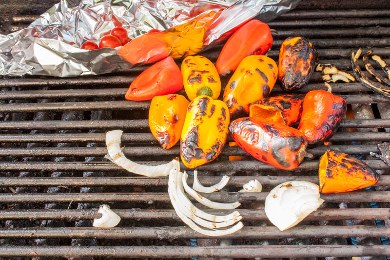 peppers, onions and tomatoes on the grill