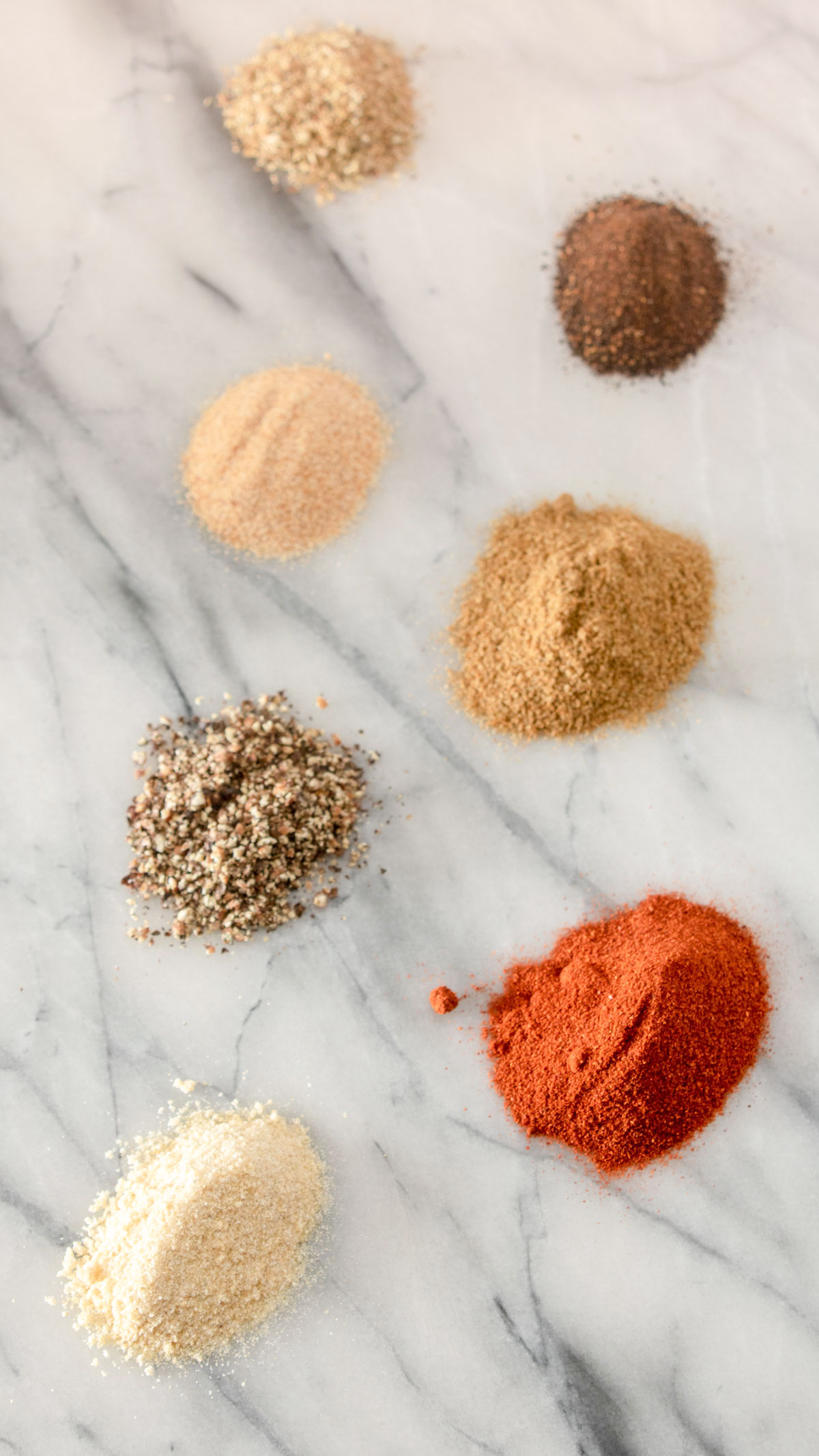 Spices in individual piles on marble board. Spices in individual piles on marble board.