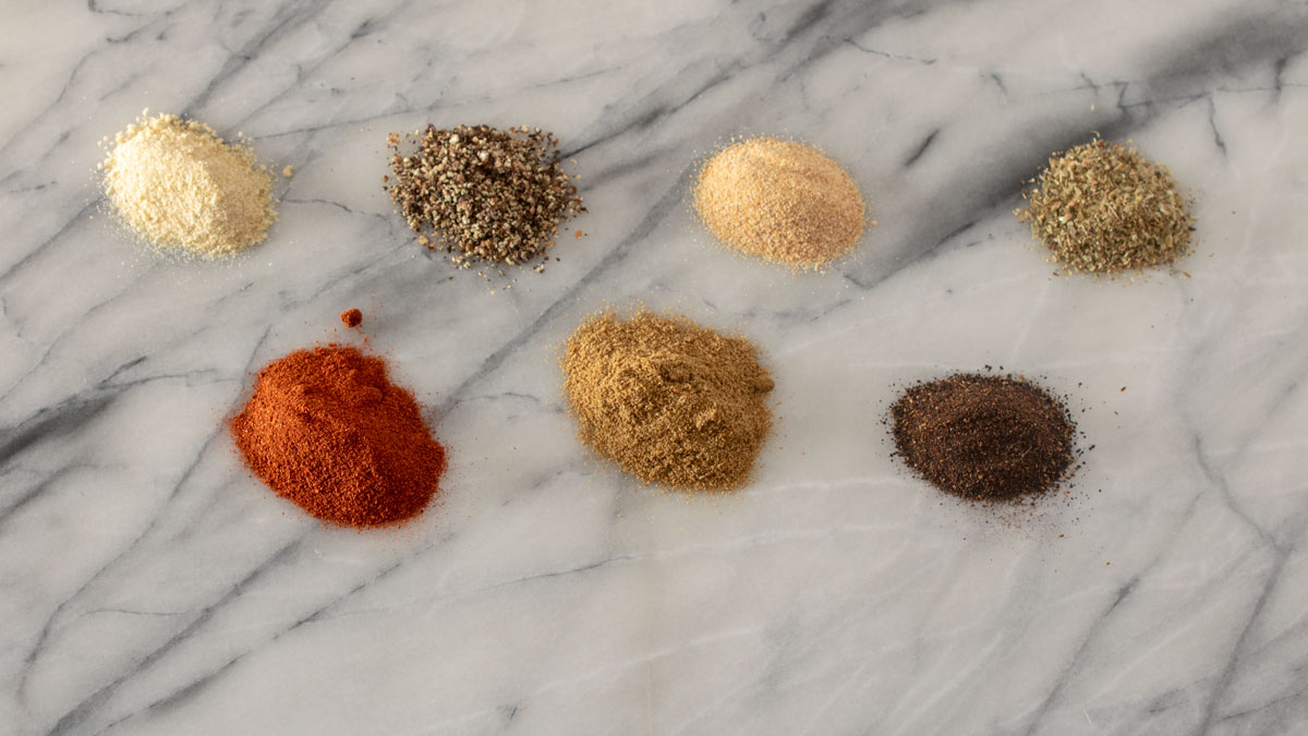 Spices in individual piles on marble board. Spices in individual bowls on marble board.