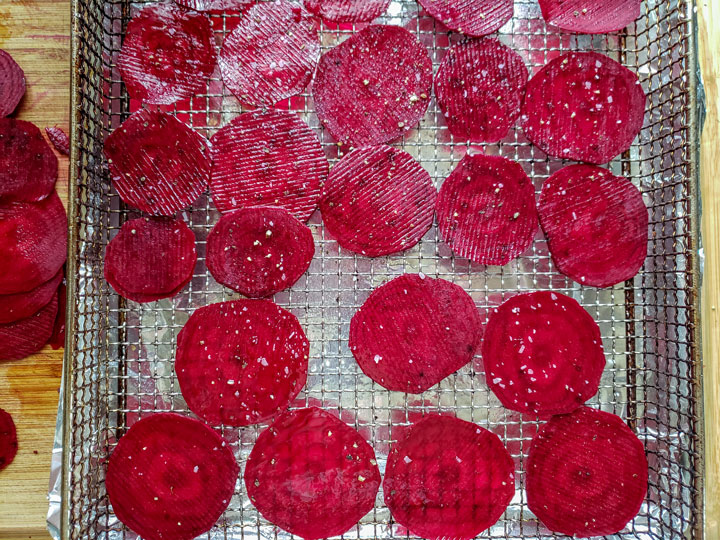 sliced beet chips. Beet chips arranged on air fryer basket.