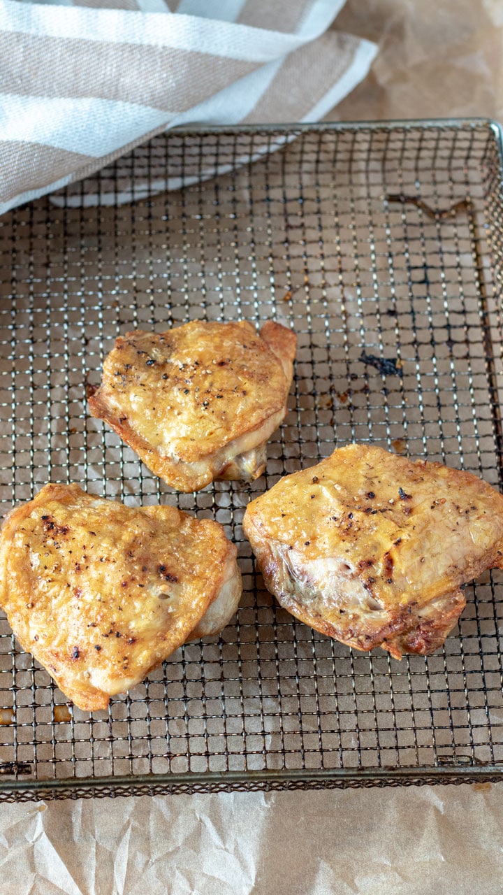 Chicken pieces on air fryer basket.