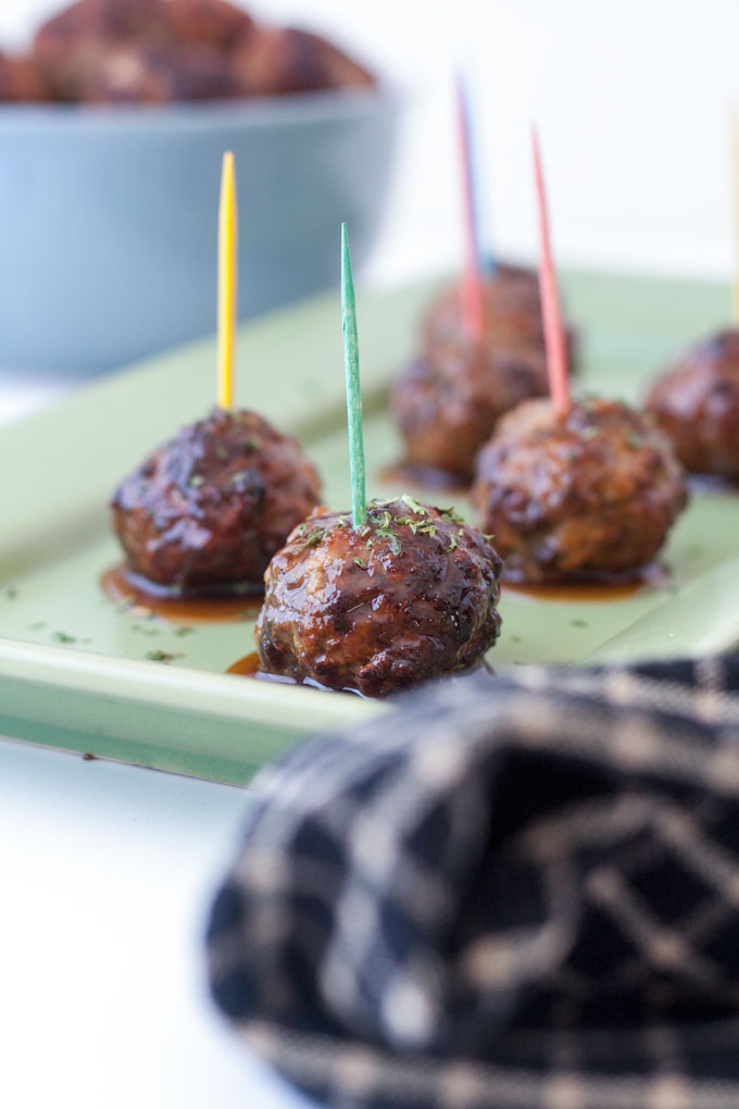close up of air fryer meatballs with sauce on green plate