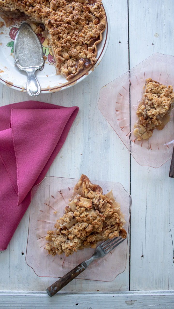 2 slices of pie on pink plates on white board.
