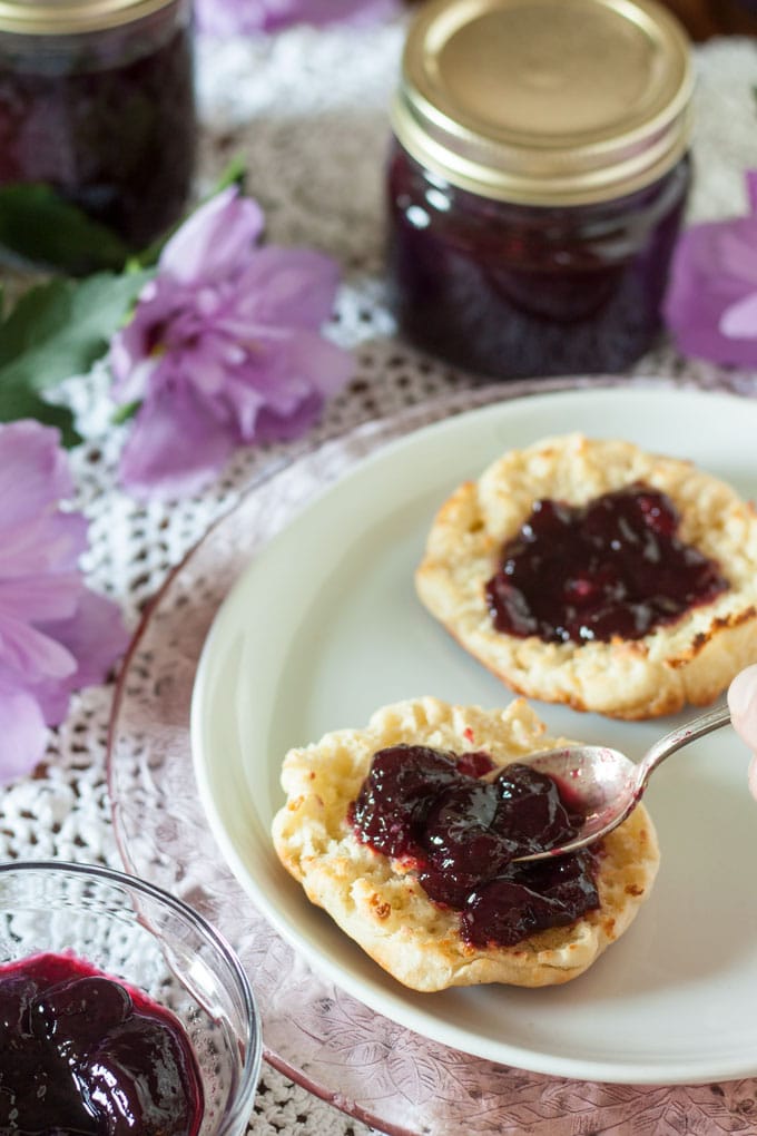 hand spreading jam on muffin