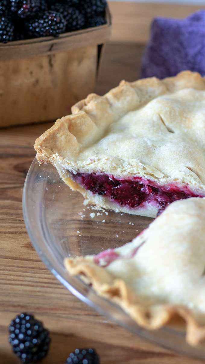 Cut blackberry pie in glass pie plate