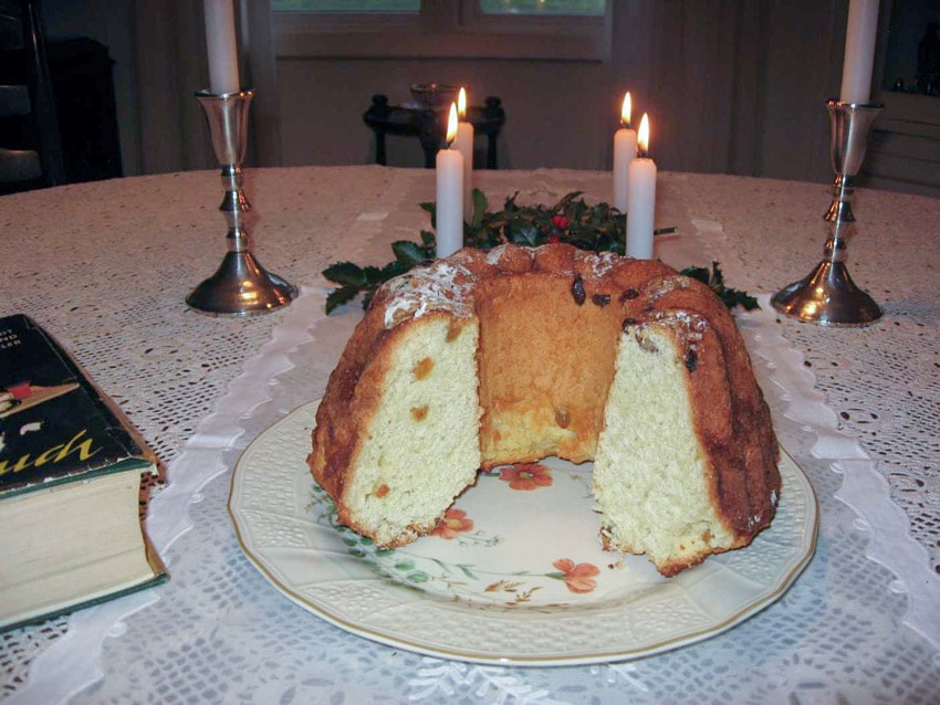 Cut Gugelhopf on a flowered plate and a lace tablecloth