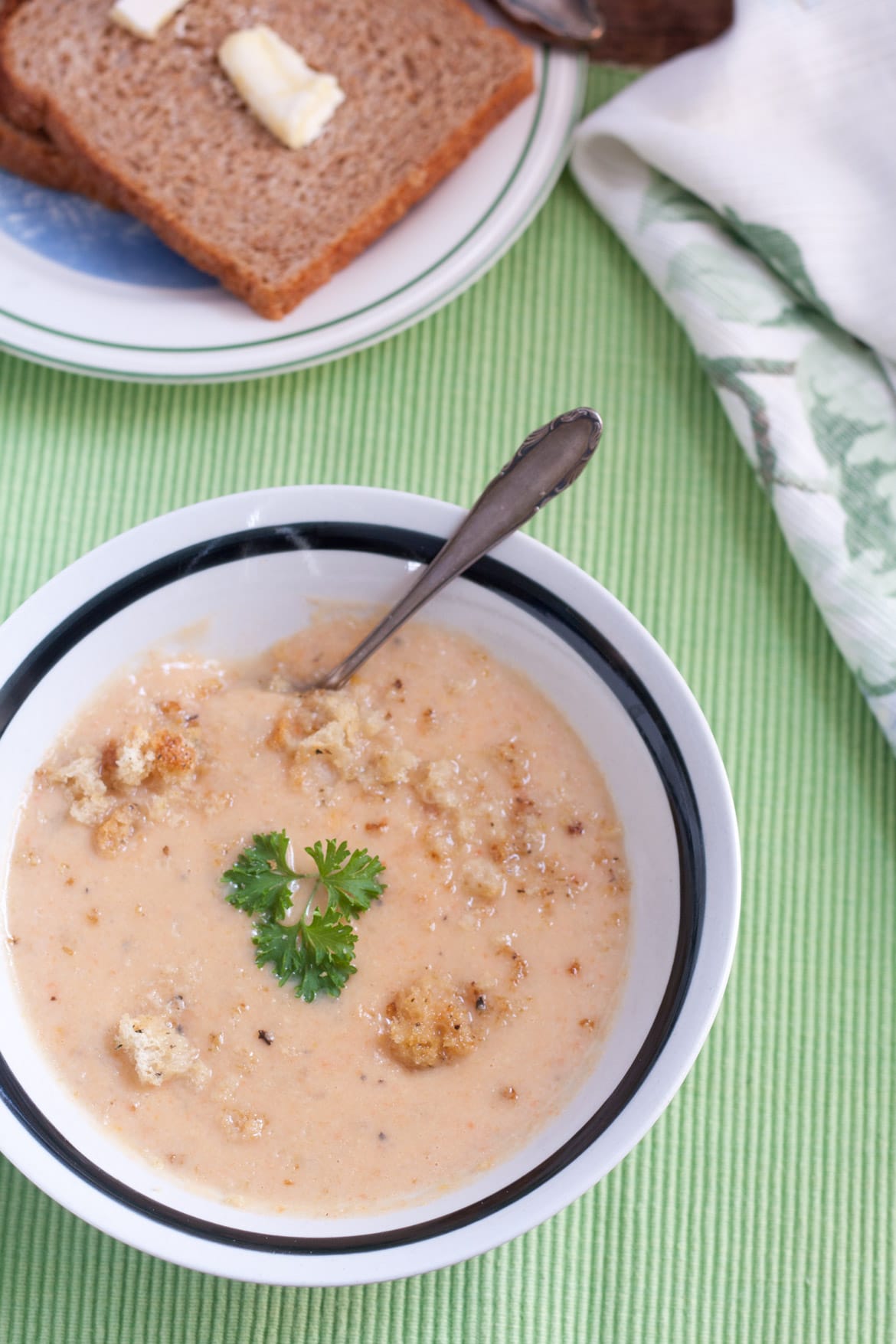 Peach colored cauliflower cheese soup with croutons on top