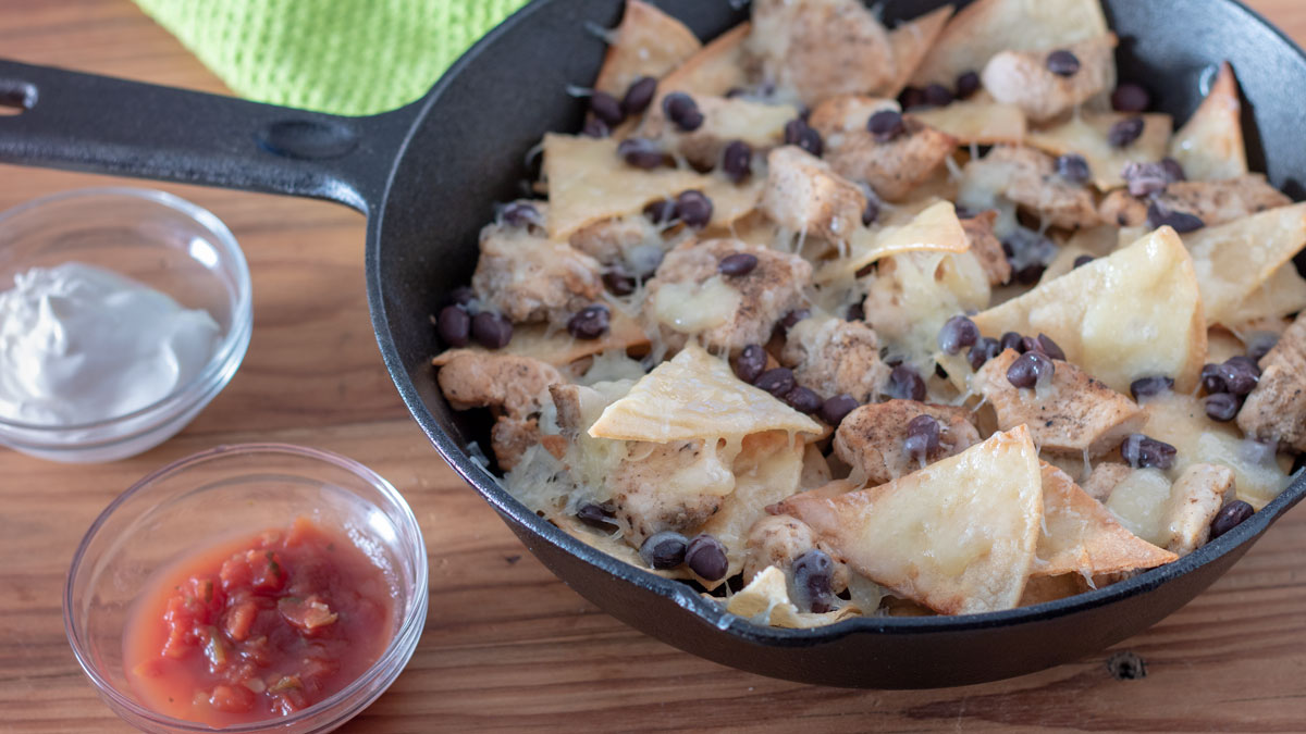 Chicken nachos in cast iron skillet.