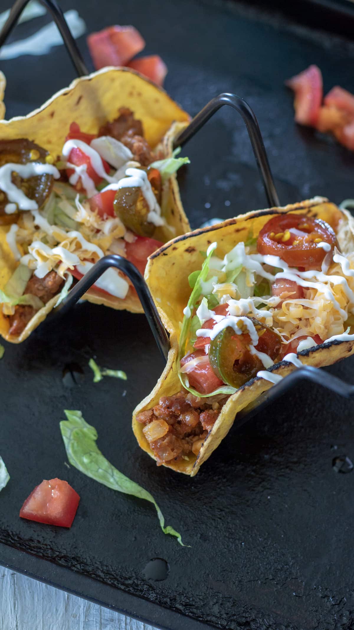 2 chorizo tacos in taco holder topped with colorful toppings.