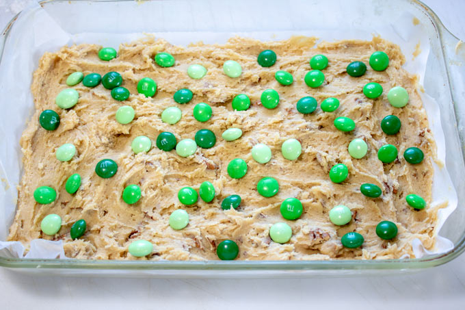 raw cookie bars in baking pan topped with M&M's
