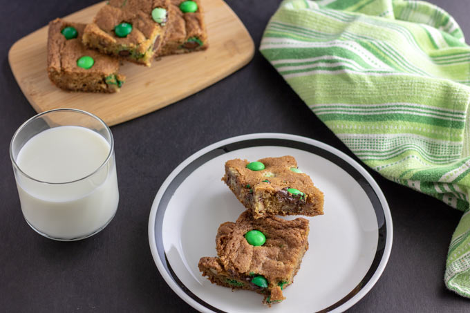 two cookie bars on white plate with milk