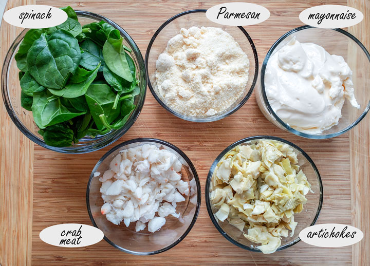 Hot crab dip ingredients on on bamboo board.