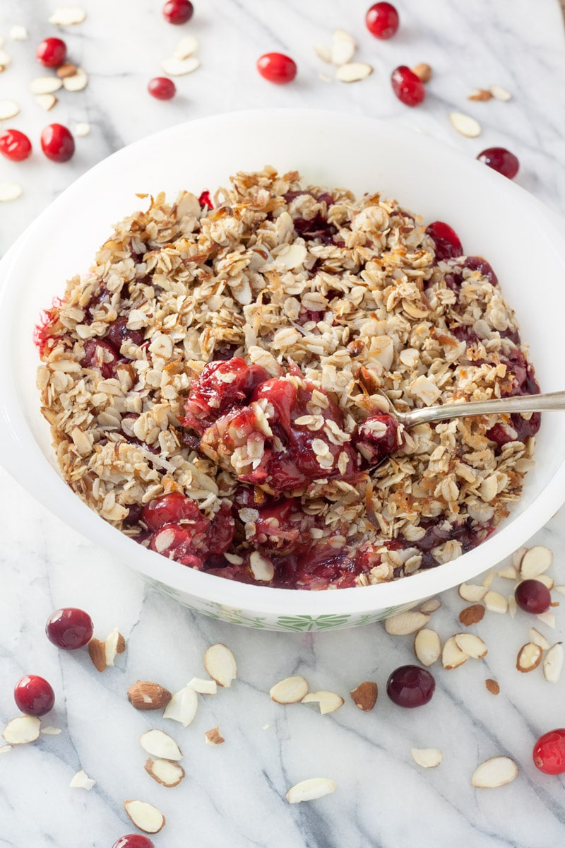 Spoon scooping out cranberry cherry crisp.