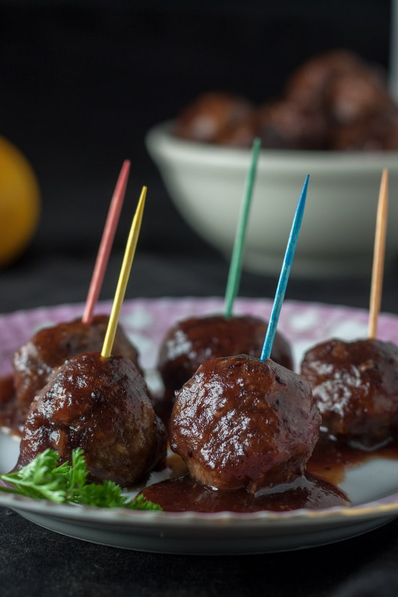 Cranberry Orange Meatballs on pink plate with colored toothpicks