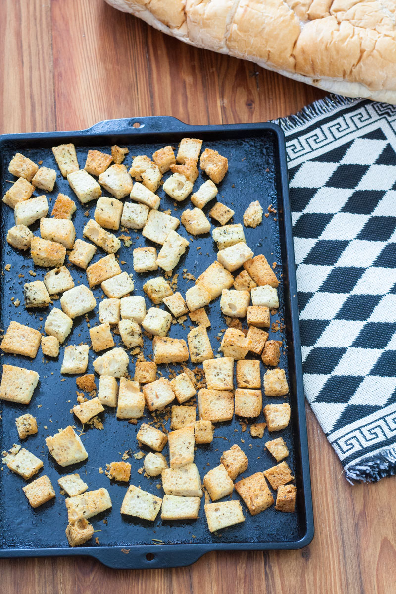 Croutons on baking sheet. with black and white towel.