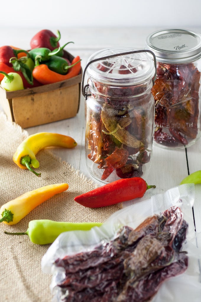 dried pepprs packed in jars and vacuum packed on burlap background