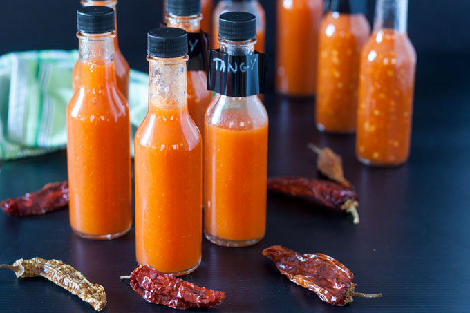 fermented hot sauce in bottles on black background