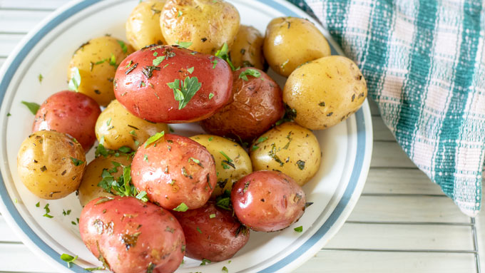 Grilled potatoes with fresh herbs on top.