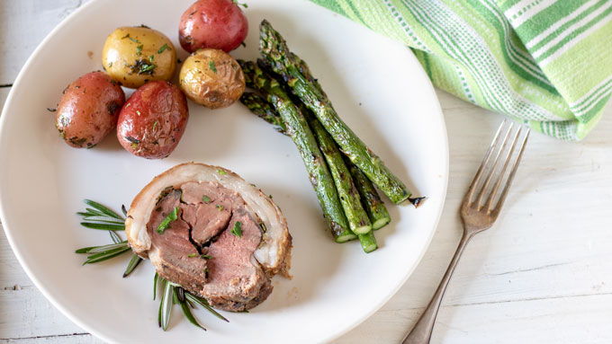 Grilled potatoes on dinner plate with meat and vegetable.