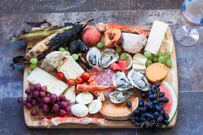 Mixed seafood charcuterie on a wooden cutting board.
