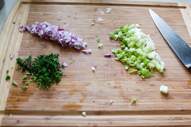 cut up red onion, celery and parsley on cutting board