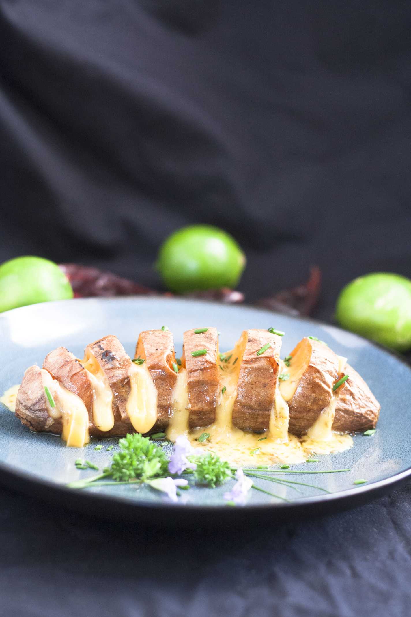 Hasselbeck Style Sweet Potatoes on blue plate with melty cheese