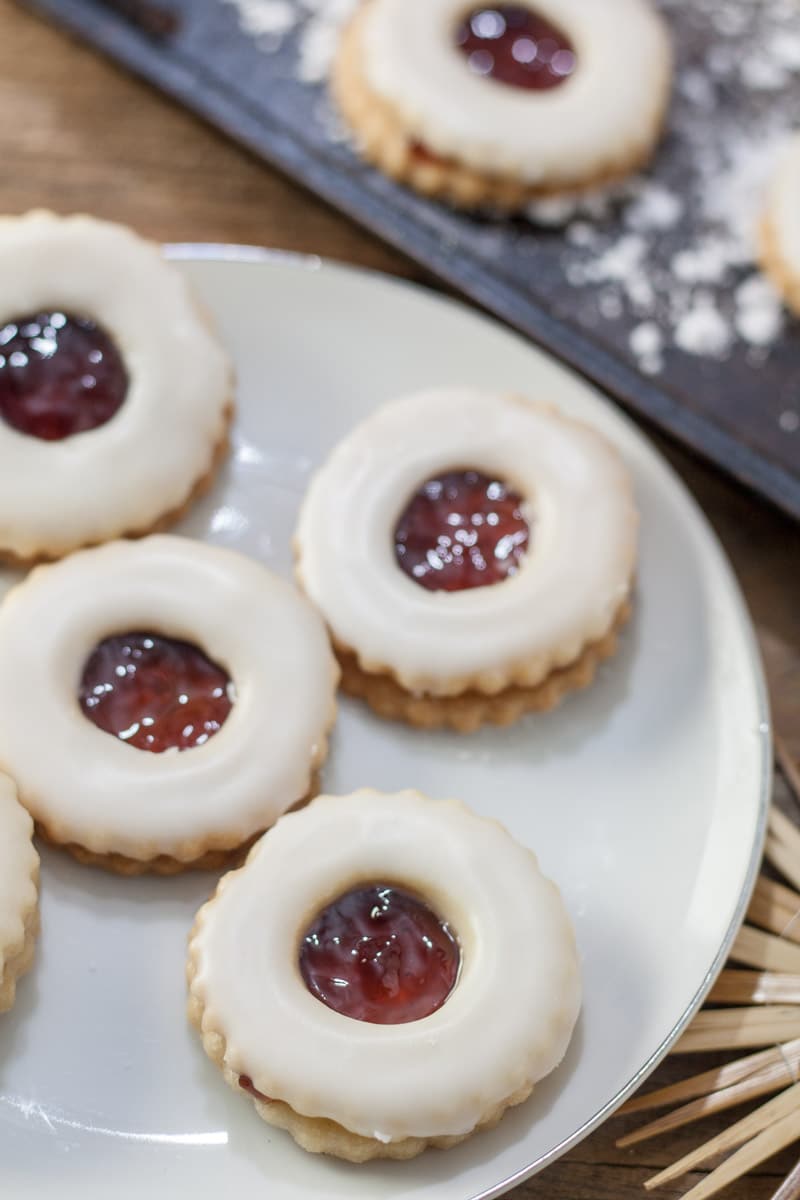 Jam filled Christmas cookies on plate.
