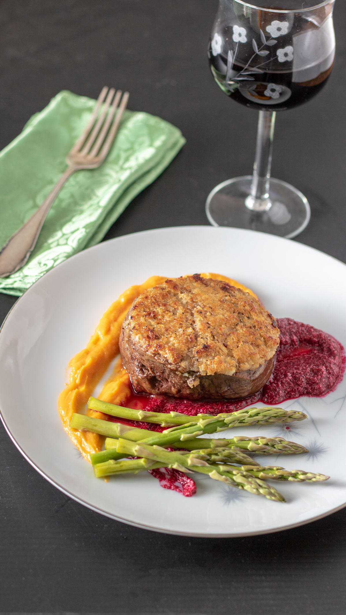Beef filet on white plate with colorful vegetable purees