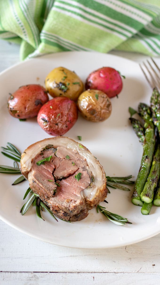 grilled asparagus with lamb loin on white plate