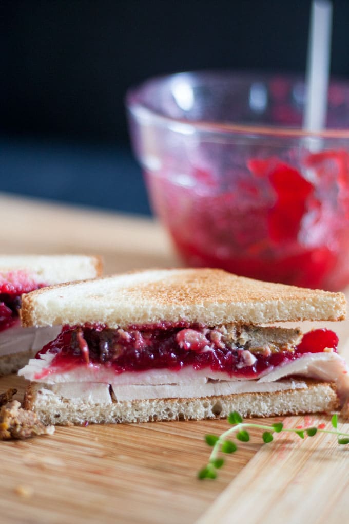 close up of cut edge of thrkey sandwich, showing layers of cranberry, turkey and stuffing