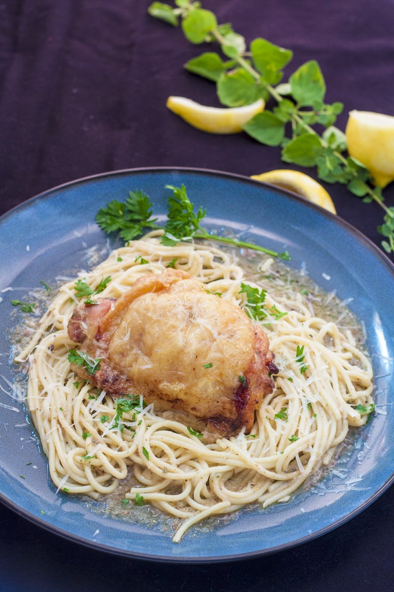 chicken and spaghetti garnished with lemon and parsley