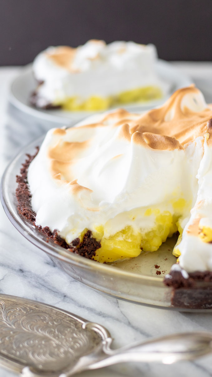 Slice of gluten free lemon meringue pie on white plate.