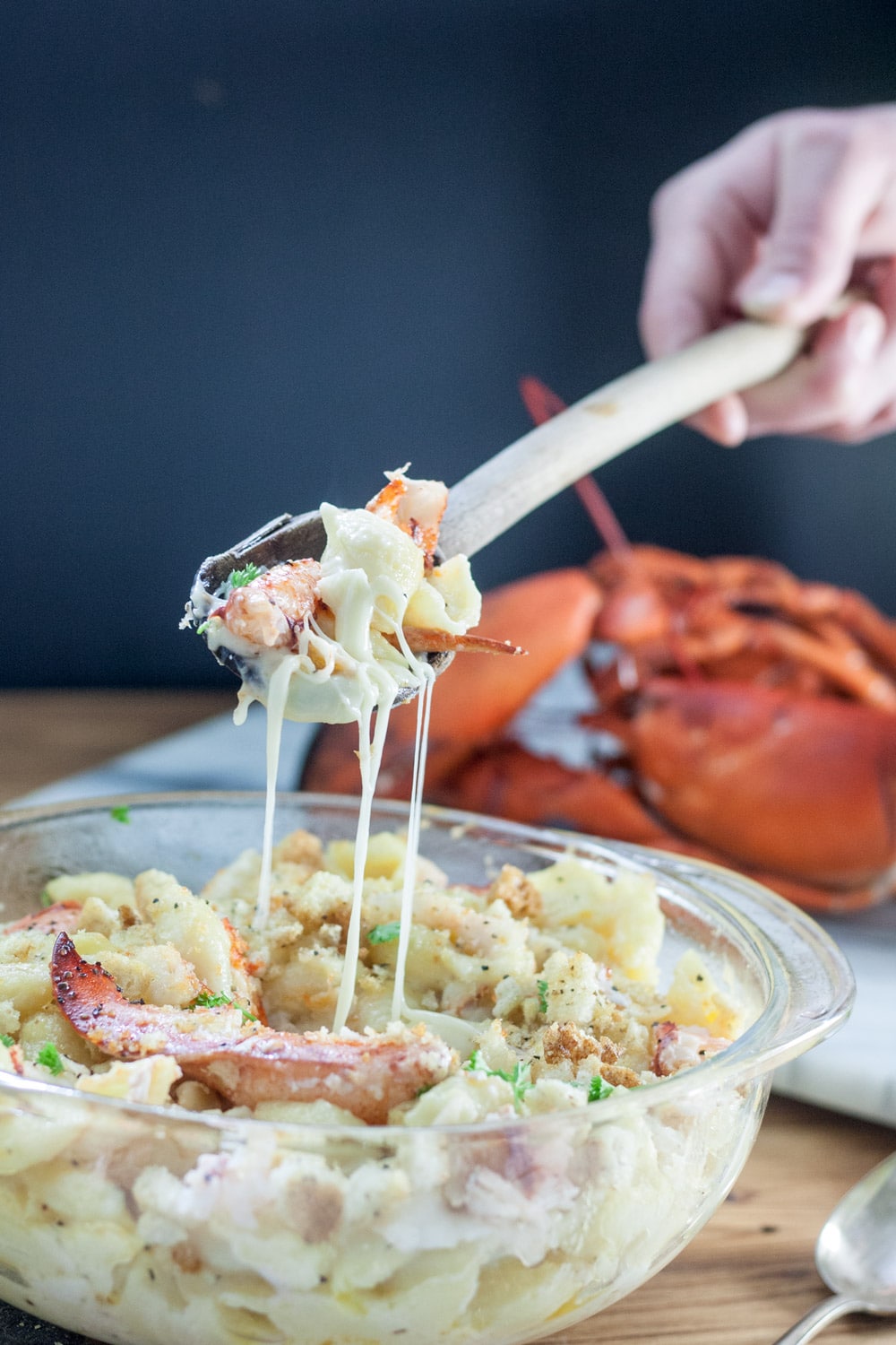 lobster mac and cheese on spoon, dripping with cheese
