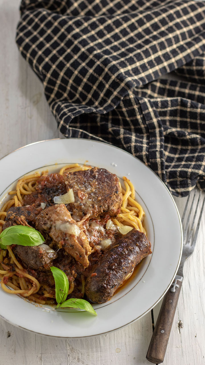 Meaty pasta sauce covering cooked spaghetti.