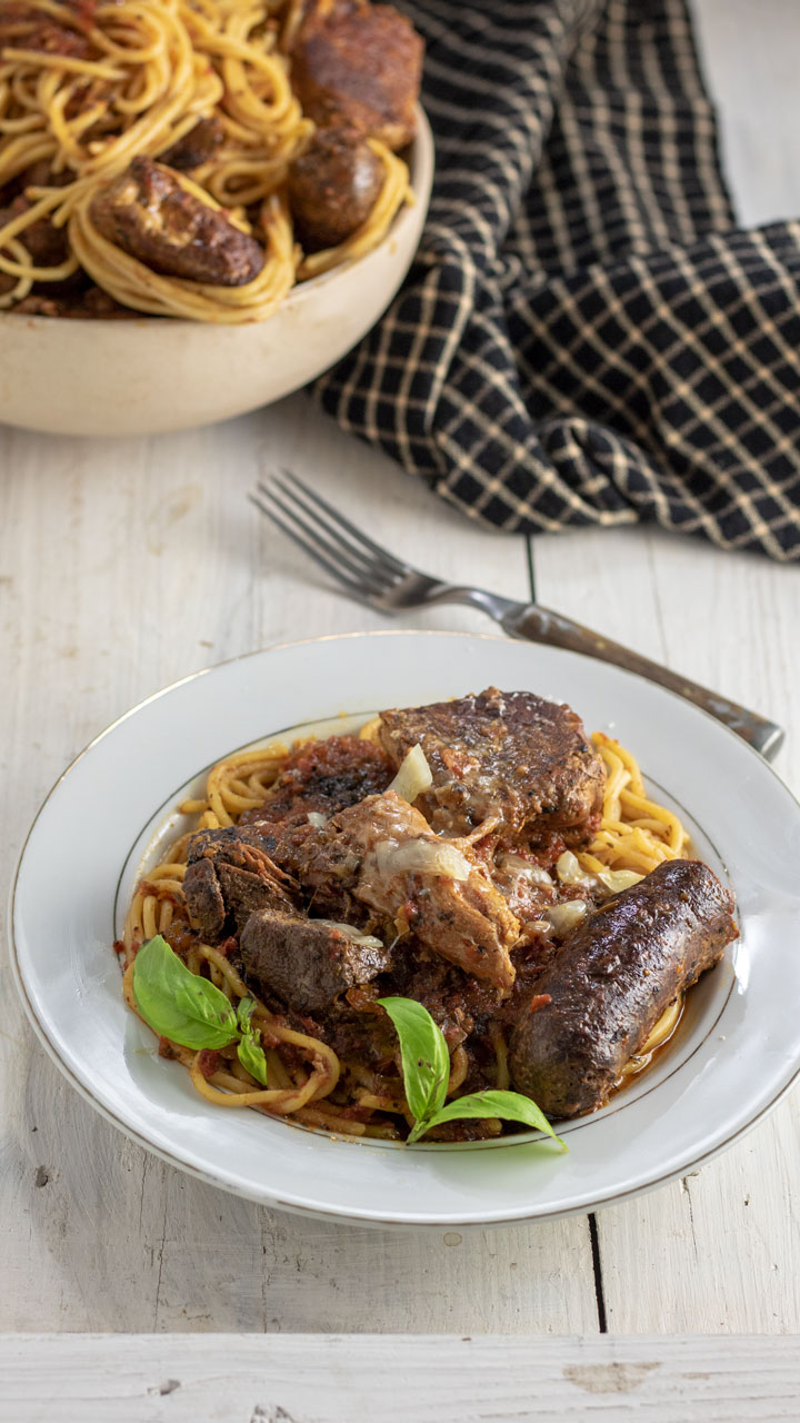 Bolognese on white plate with cheese.