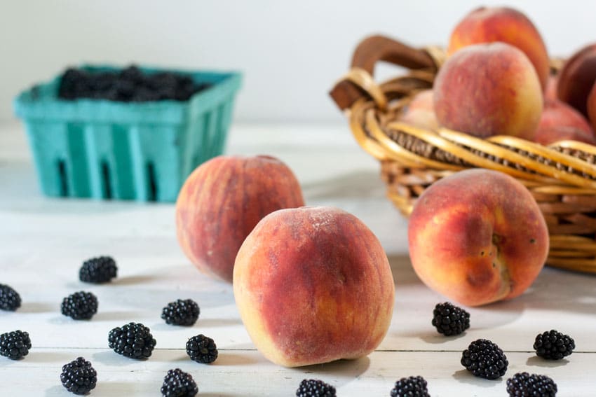 peaches and blackberries on white board