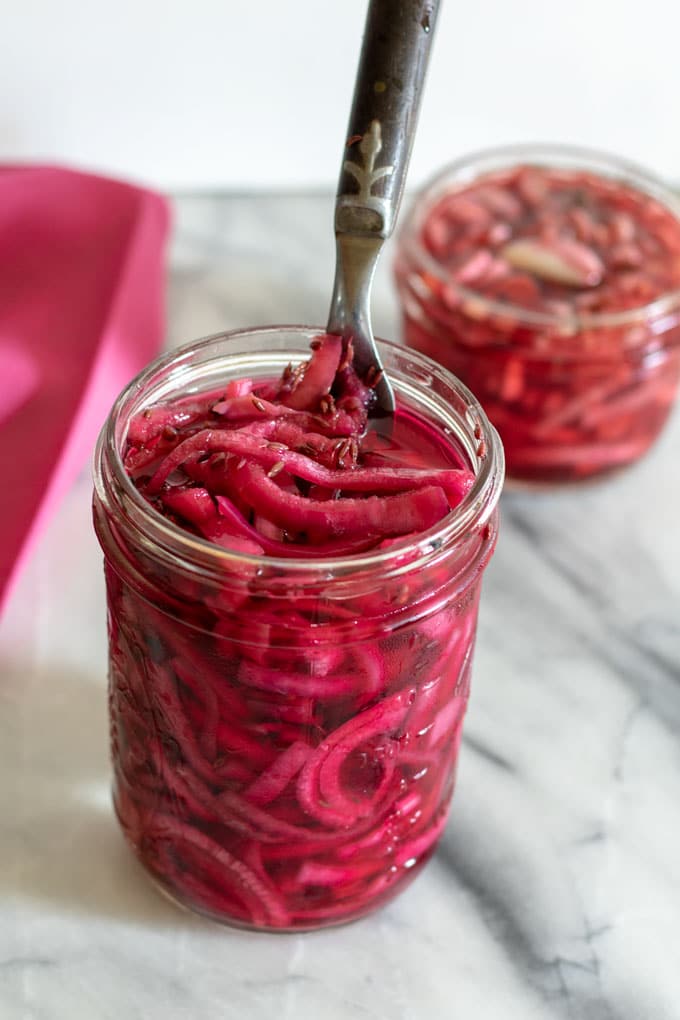 pickled red onions in mason jar with fork