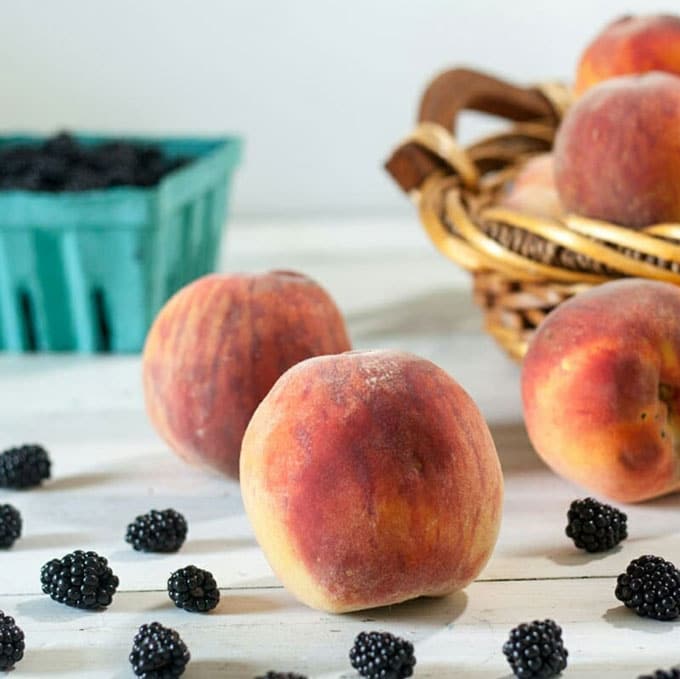 peaches and blackberries on white background