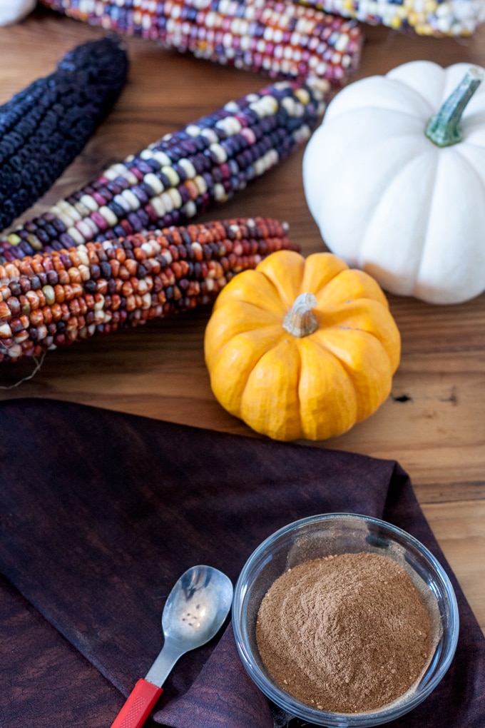 pumpkin pie spice mixed up in small glass bowl with pumpkins