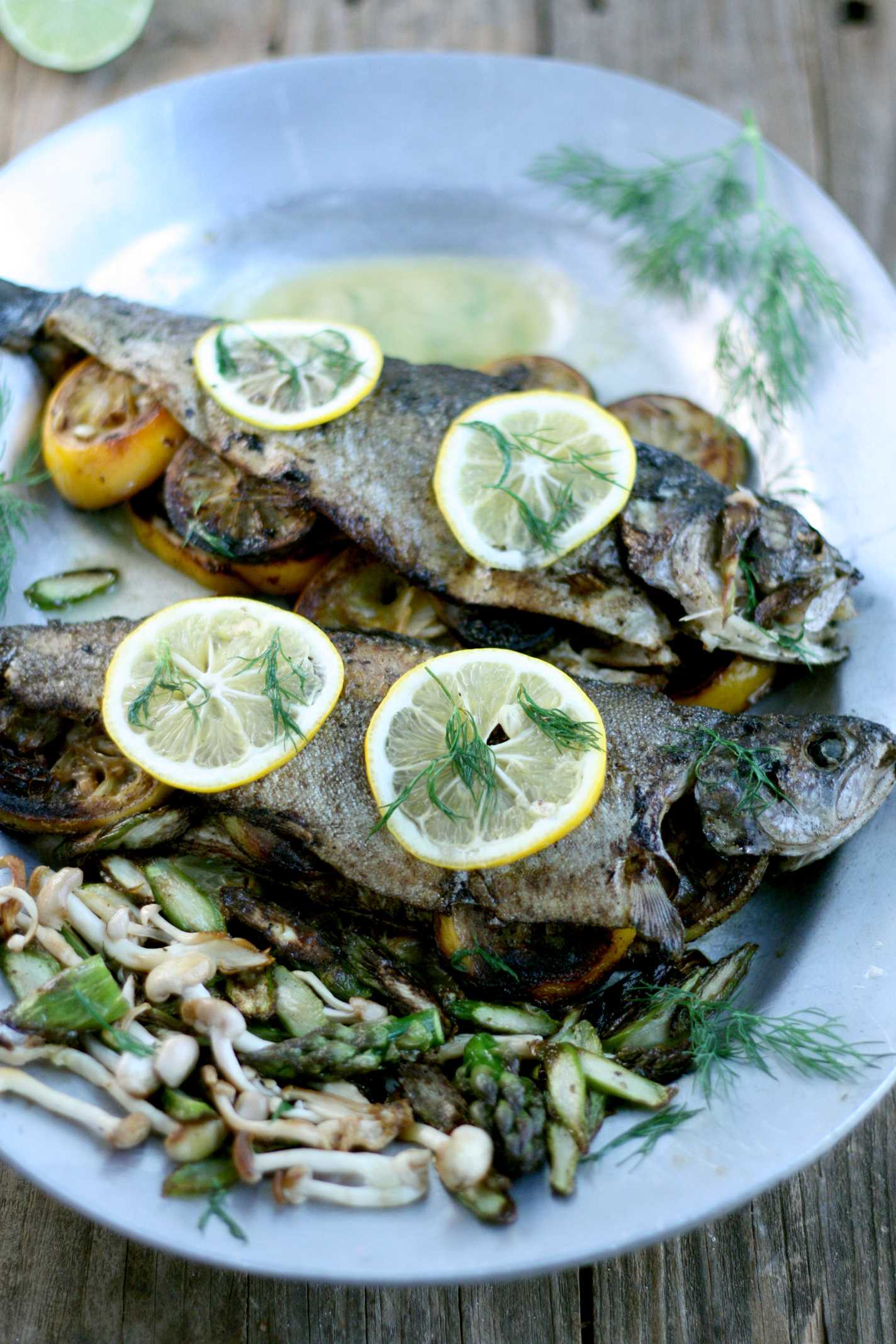 whole trout on pewter tray garnished with lemons