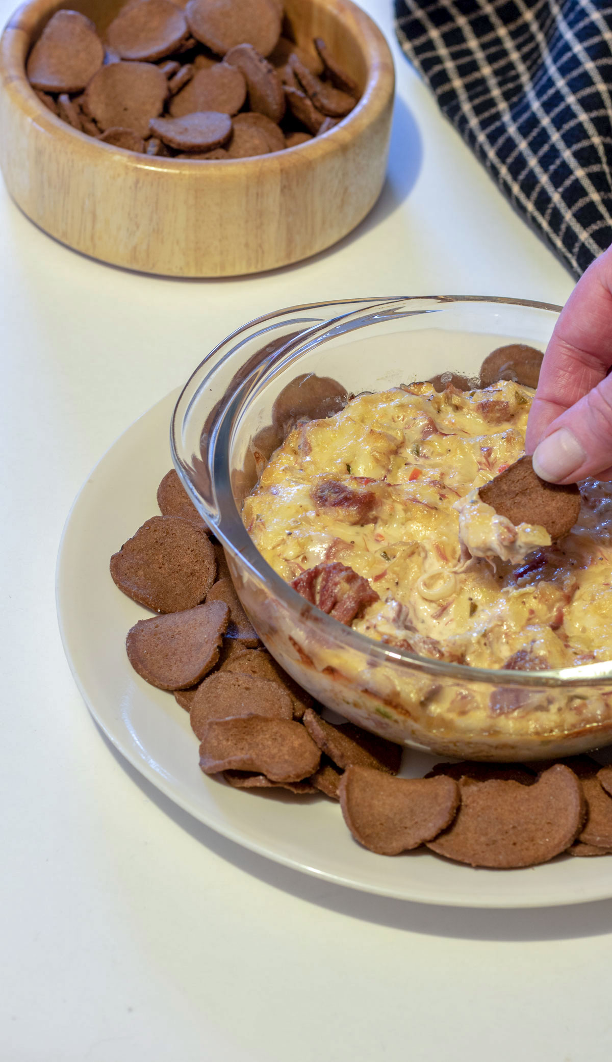 Hand scooping Reuben dip from casserole.