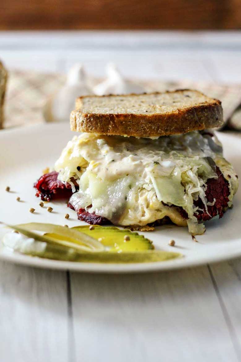 reuben sandwich dripping with cheese