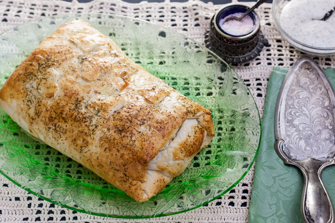 whole salmon wellington on green platter