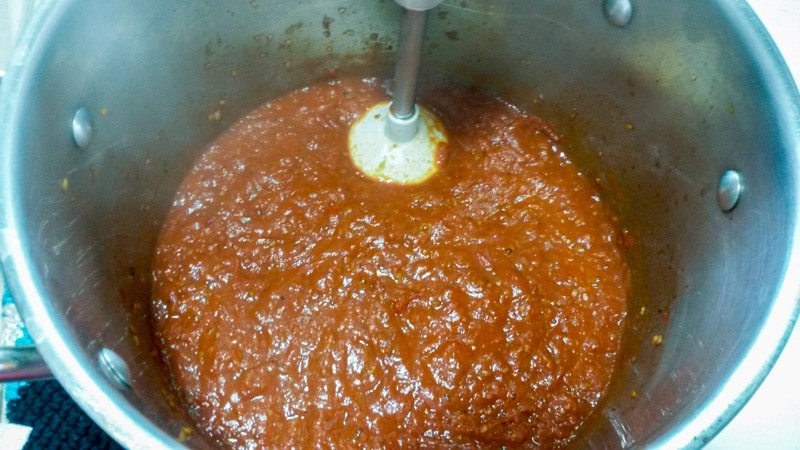 Cooked down roasted tomatoes in pot with immersion blender, to make a creamier sauce.