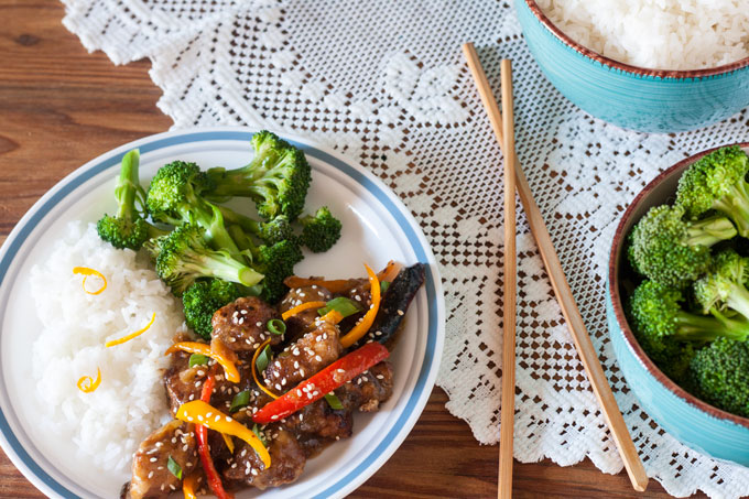 Sesame Orange Chicken stir fry on white plate with chopsticks