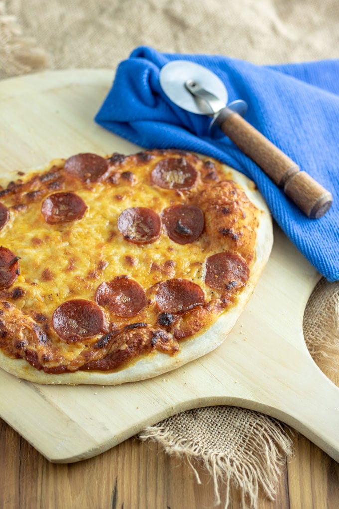pepperoni pizza with wooden handle pizza cutter