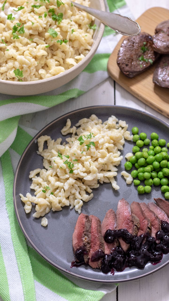 Spaetzle served with peas and duck breast.