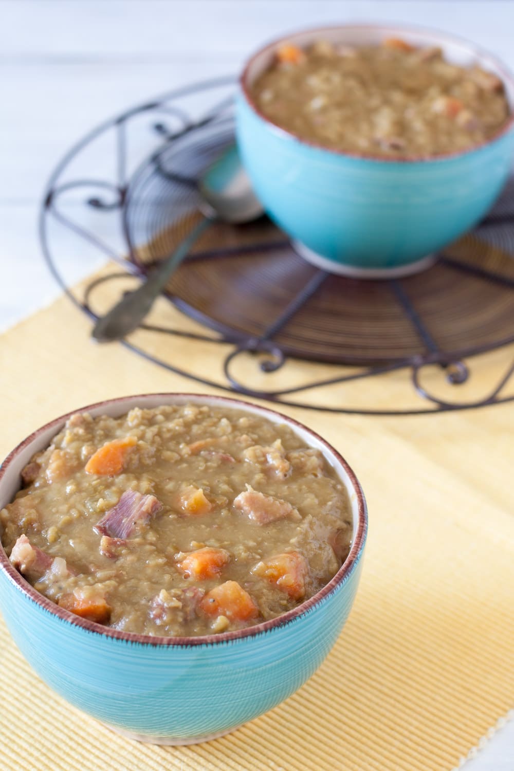 Split pea soup in blue bowl on yellow placemat